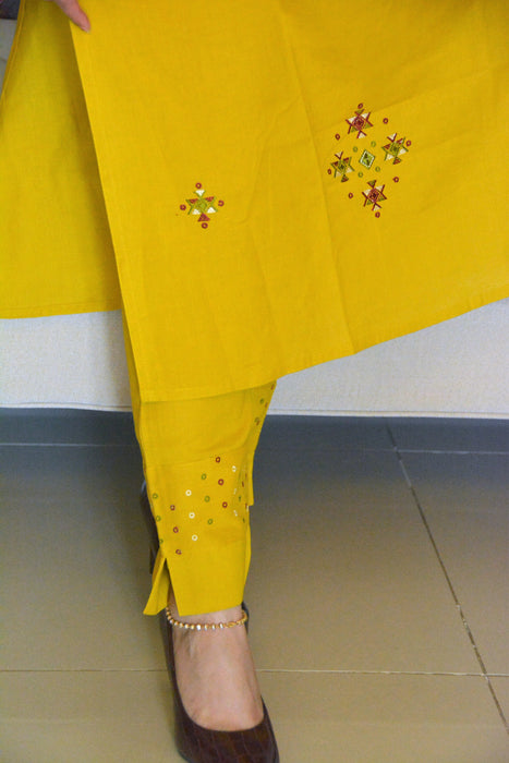 Mustard yellow kurta set with embroidery motifs on kurta and smart pants with details at cuts
