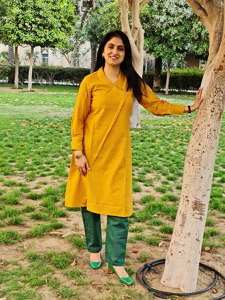 Mustard yellow A line kurta with angarkha cut in self stripes paired with contrast emarald green pants in stripes